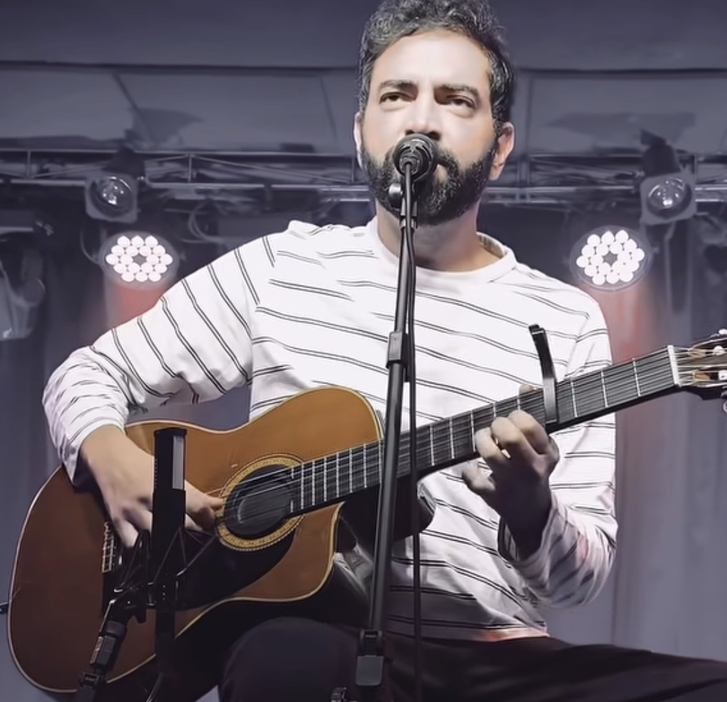 Diego Tavares tocando violão no palco